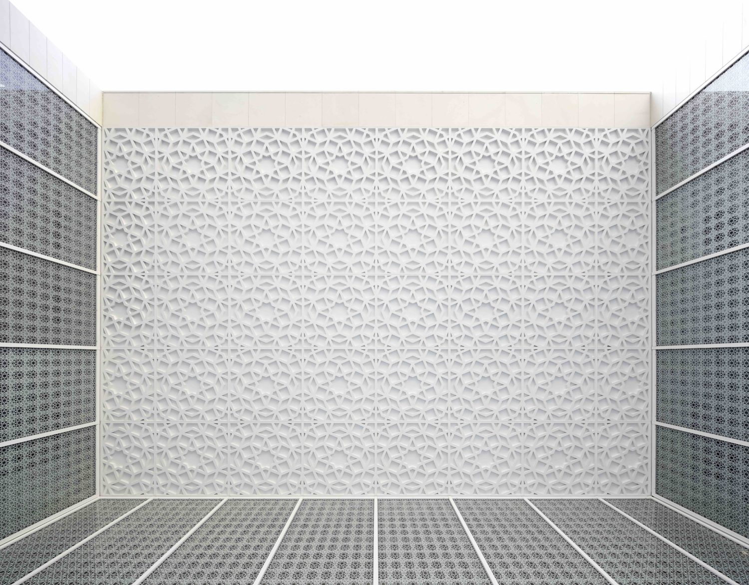 The view looking up in the Garden of Tranquillity. This features glass walls with Islamic patterns and a white ceiling with embossed Islamic patterns.