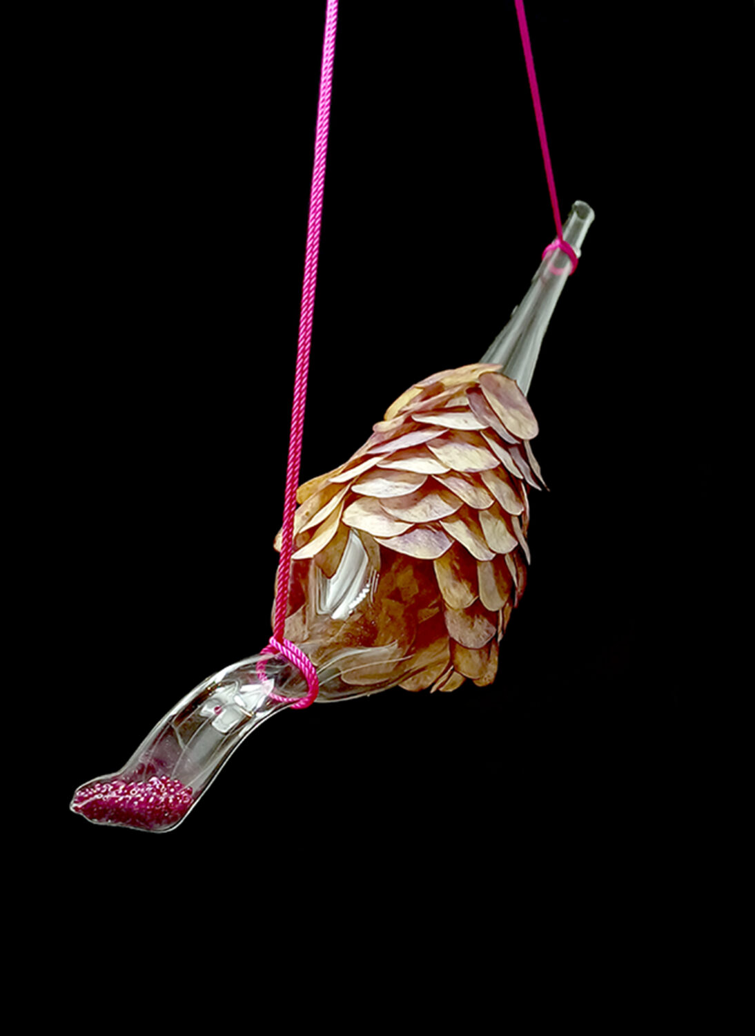 A glass hanging object with pinecone-like scales over it